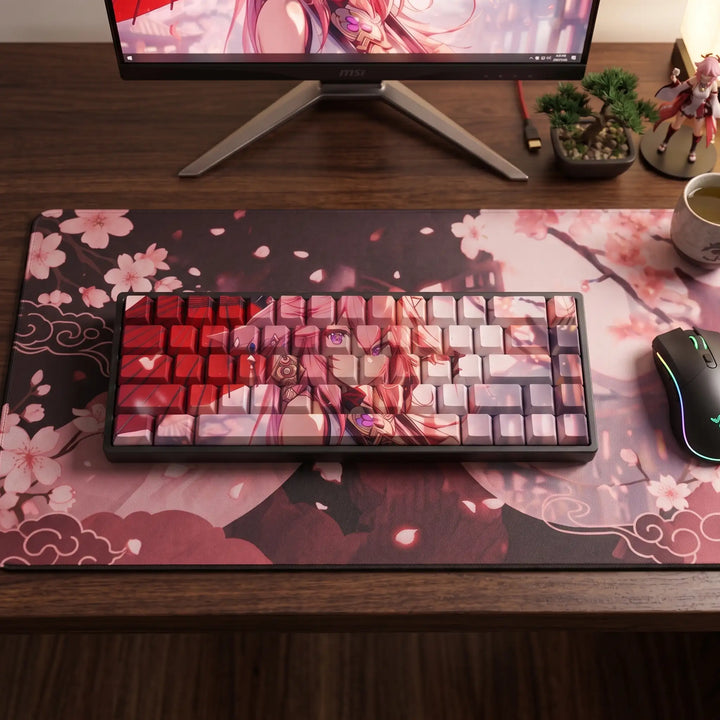 Top view of Yae Miko keycaps on a compact keyboard with a cherry blossom desk mat